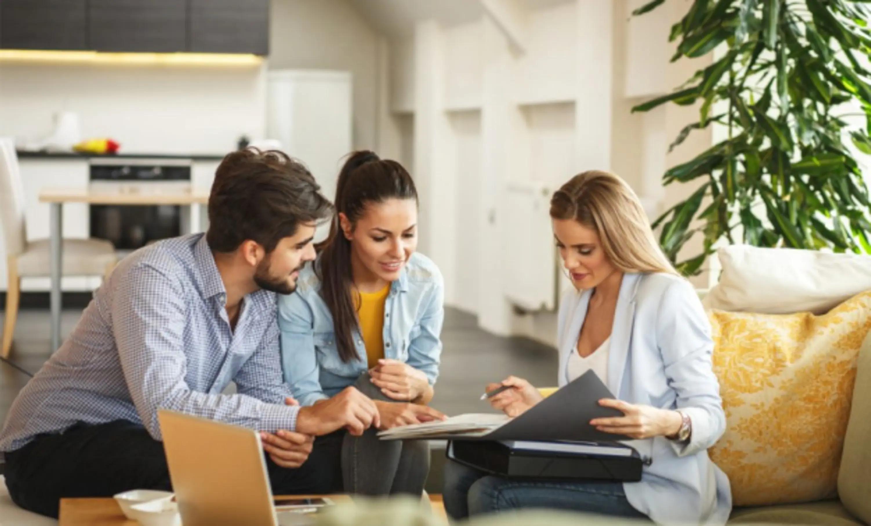 Homebuyers review a contract with their real estate agent.